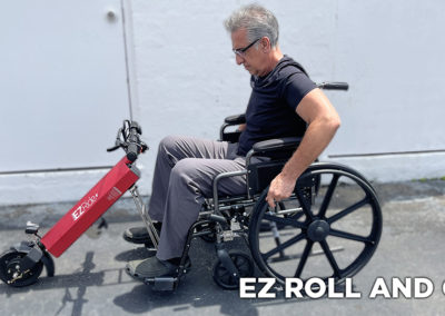 An image of a man sitting in a manual wheelchair preparing to connect to his EZRide unit waiting with the kickstand extended. The text states "EZ roll and go"