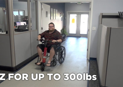 An image of a larger man sitting in a manual wheelchair with the EZRide unit connected. Text states that it's "EZ for up to 300 pounds"